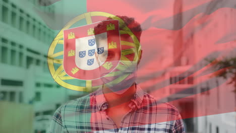 animation of flag of portugal waving over man wearing face mask during covid 19 pandemic