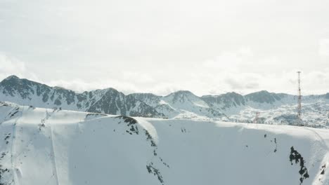 A-push-towards-a-mountain-top-with-a-skiiers,-ski-lifts-and-a-communications-tower