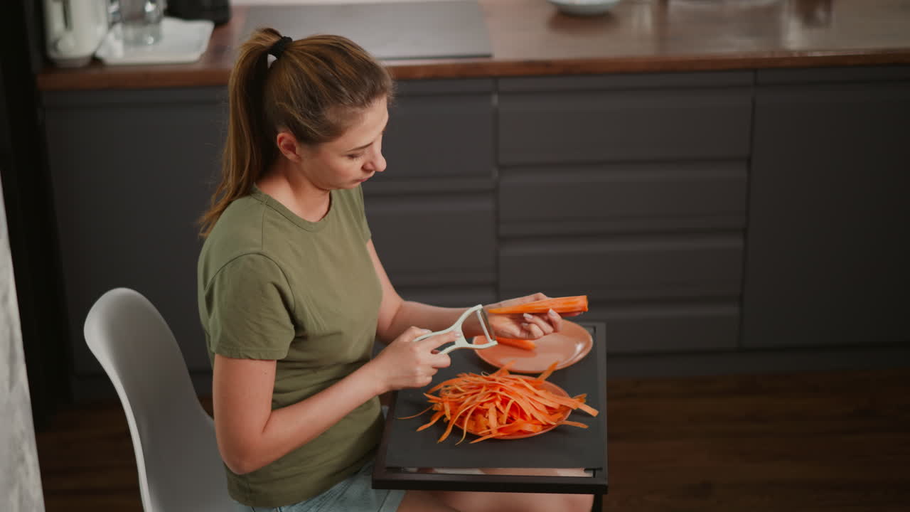 Woman preparing carrots in the kitchen