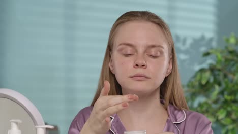 mujer aplicando crema facial