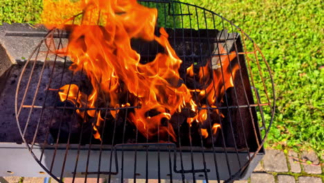 charcoal grill with open flames and glowing coals burning hot at start of outdoor cookout