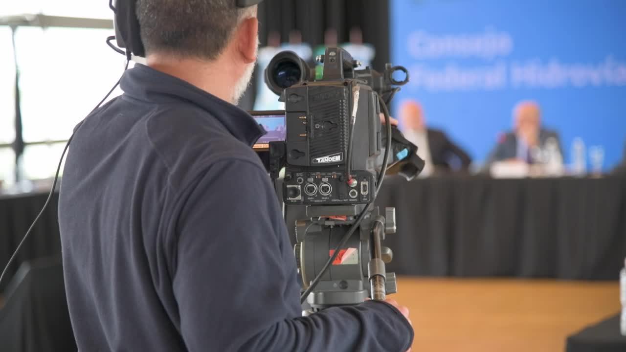 el camarógrafo graba un video con su cámara en un acto político