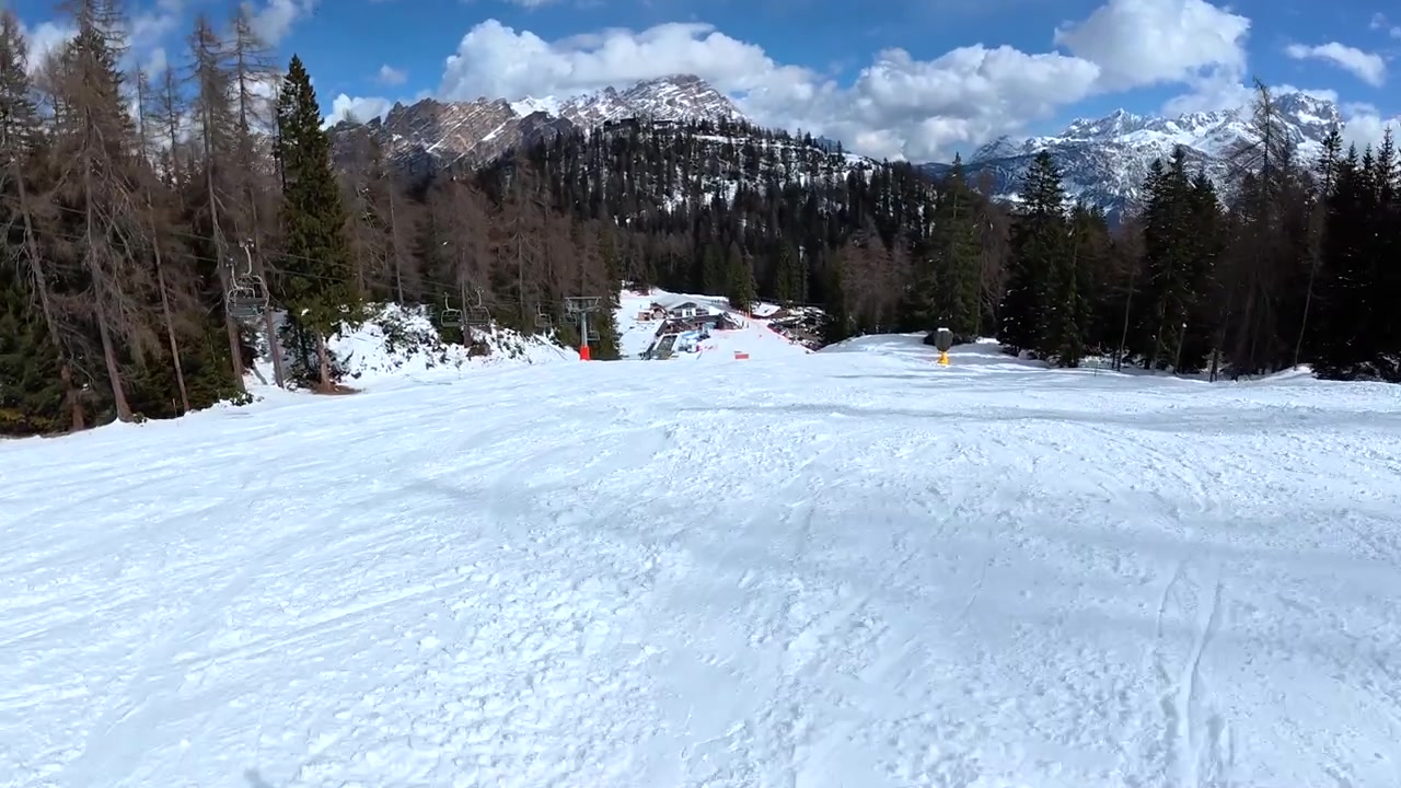 Vista in prima persona di uno sciatore che scende un pendio montano innevato