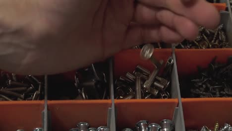 Master who produces and installs furniture pours many bolts into the cell in the suitcase Close-up Slow motion