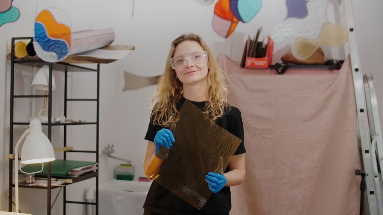 Woman holding glass in art studio