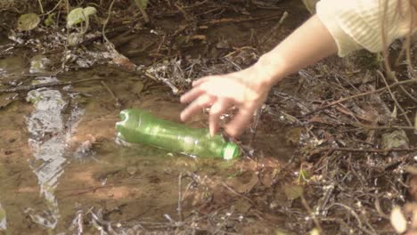 conservation getting a plastic bottle polluting countryside stream