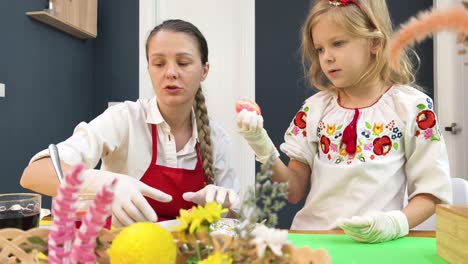madre e hija decorando huevos de pascua