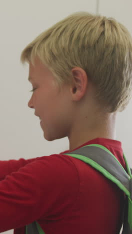 video of caucasian boy closing locker and smiling at school