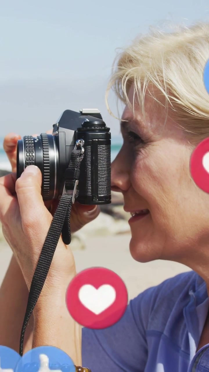 Video verticale: Donna che alza la fotocamera facendo fluttuare icone, poi l'abbassa, guardando il mare per i social media