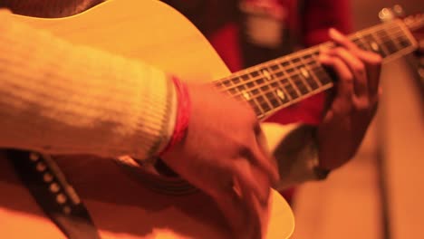 Extreme-Nahaufnahme-Eines-Menschen,-Der-Gitarre-Spielt,-Unter-Der-Straßenlaterne-In-Der-Nacht,-Auf-Einem-Ghat-In-Varanasi,-Mit-Kamerabewegung