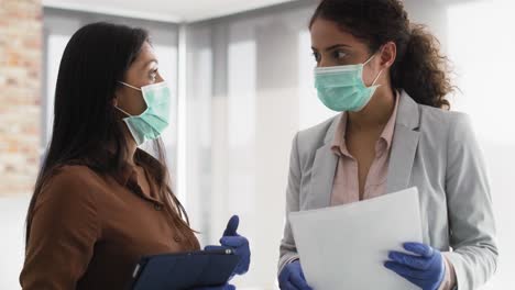 video de mujeres con máscara protectora hablando en la oficina