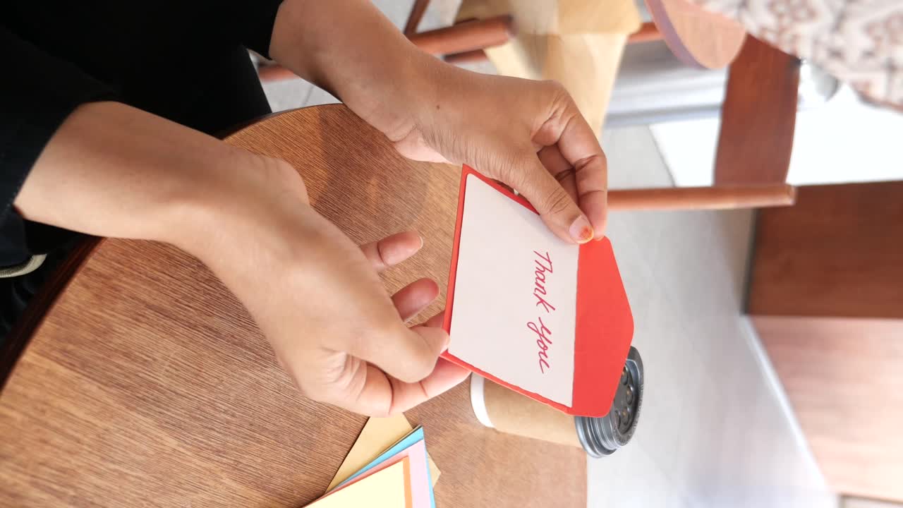 A person holding a thank you card
