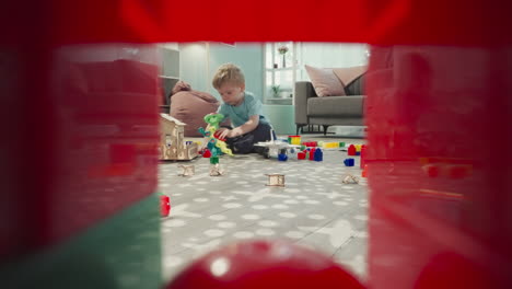 girl holds baby doll while boy playing with robot dinosaur