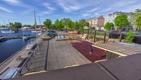 men restoring the old wooden deck at the port applying wood stain adhesive to the cleaned surface on a sunny day