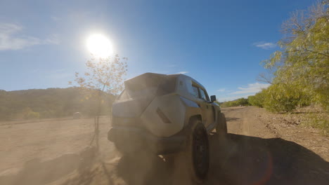 vista de drones de un auto negro en un camino polvoriento