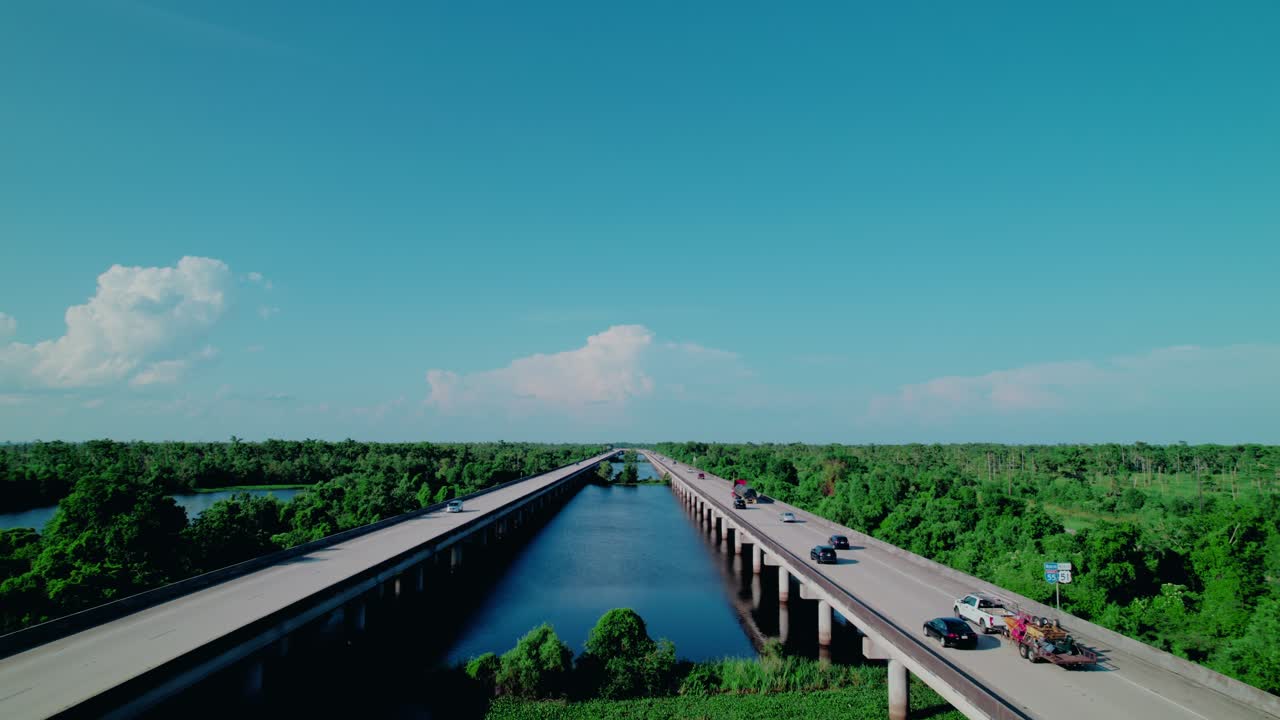 Red flatbed semi truck with load covered with tarps on bridge in LA