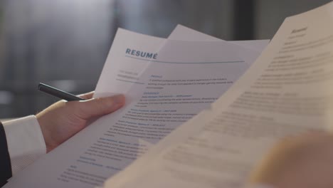 close up of businessman in office reviewing and making notes on application or cv for job vacancy 1