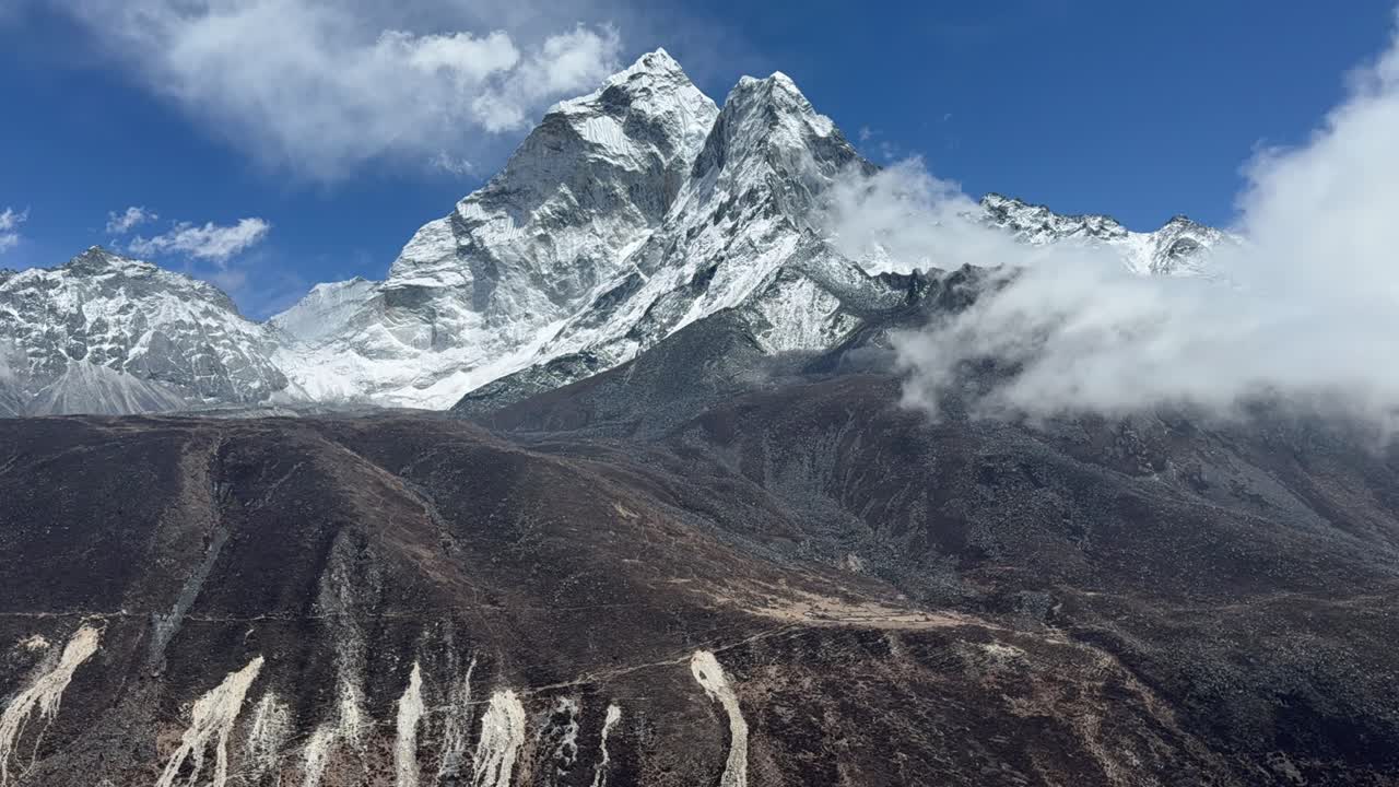 A dramatic time-lapse captures fog drifting across Himalayan mountains along the EBC route in Nepal, showcasing the raw beauty and changing weather of this high-altitude landscape.