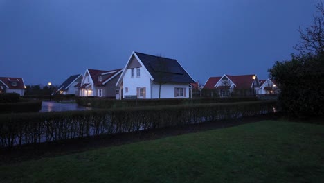 Abendansicht-Eines-Ruhigen-Wohnviertels-Während-Der-Dämmerung,-Mit-Gepflegten-Häusern-Und-Nassen-Straßen-Vom-Jüngsten-Regen