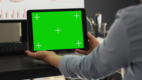 el trabajador examina la pantalla verde en la tableta