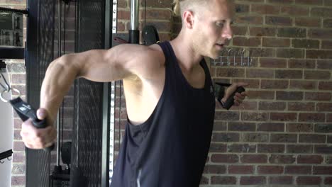 Tattooed-man-in-home-gym-shot-from-side-cable-chest-fly