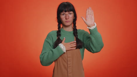 sincere responsible young nerd woman raising hand to take oath, promising to be honest, tell truth