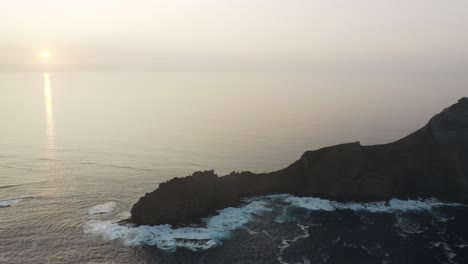 Die-Silhouette-Von-Ilhéu-Da-Cal-Mit-Steilen-Felsklippen-Und-Turbulenten-Wellen