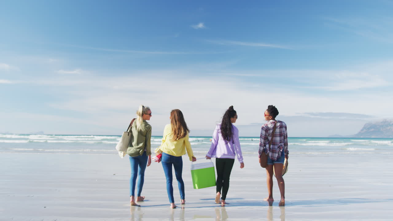 다양한 여성 친구 들 의 행복 한 그룹 이 해변 을 따라  ⁇ 고 즐겁게 지내고 있다