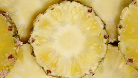 round slices of ripe pineapple slowly rotate.