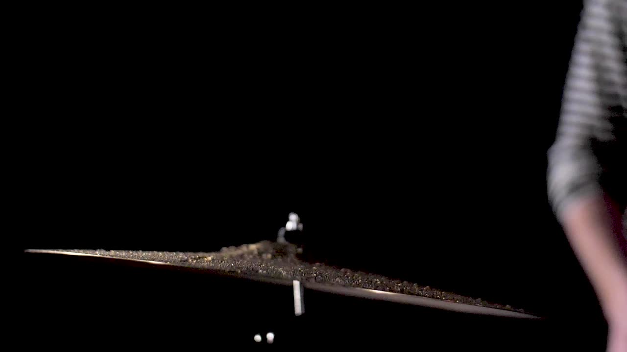 슬로우 모션: 드러머가 물에 잠긴 충돌 기호를 칩니다.