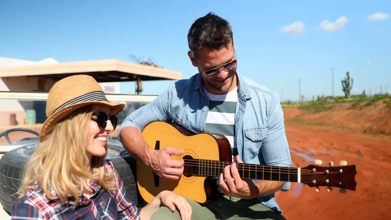 hombre tocando la guitarra para mujer 4k