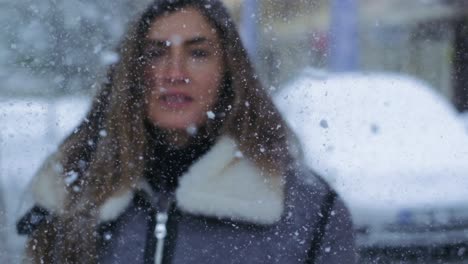 Mujer-Rubia-Dándose-La-Vuelta-Para-Mirar-A-La-Cámara-En-Cámara-Lenta-Durante-La-Caída-De-Nieve