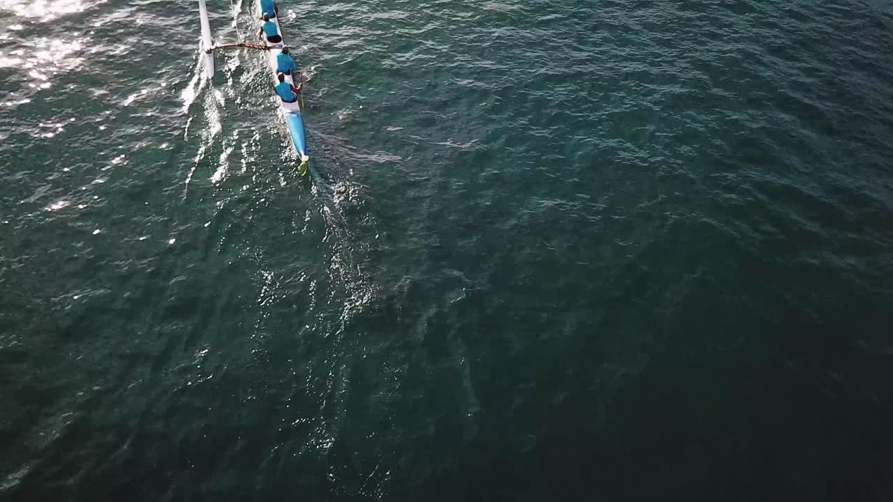 푸른 물에서 노를 젓는 아우트리거 카누 위의 아름다운 공중