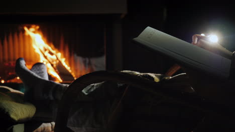 un hombre comienza a escribir en una página en blanco de un cuaderno sentado junto a la chimenea