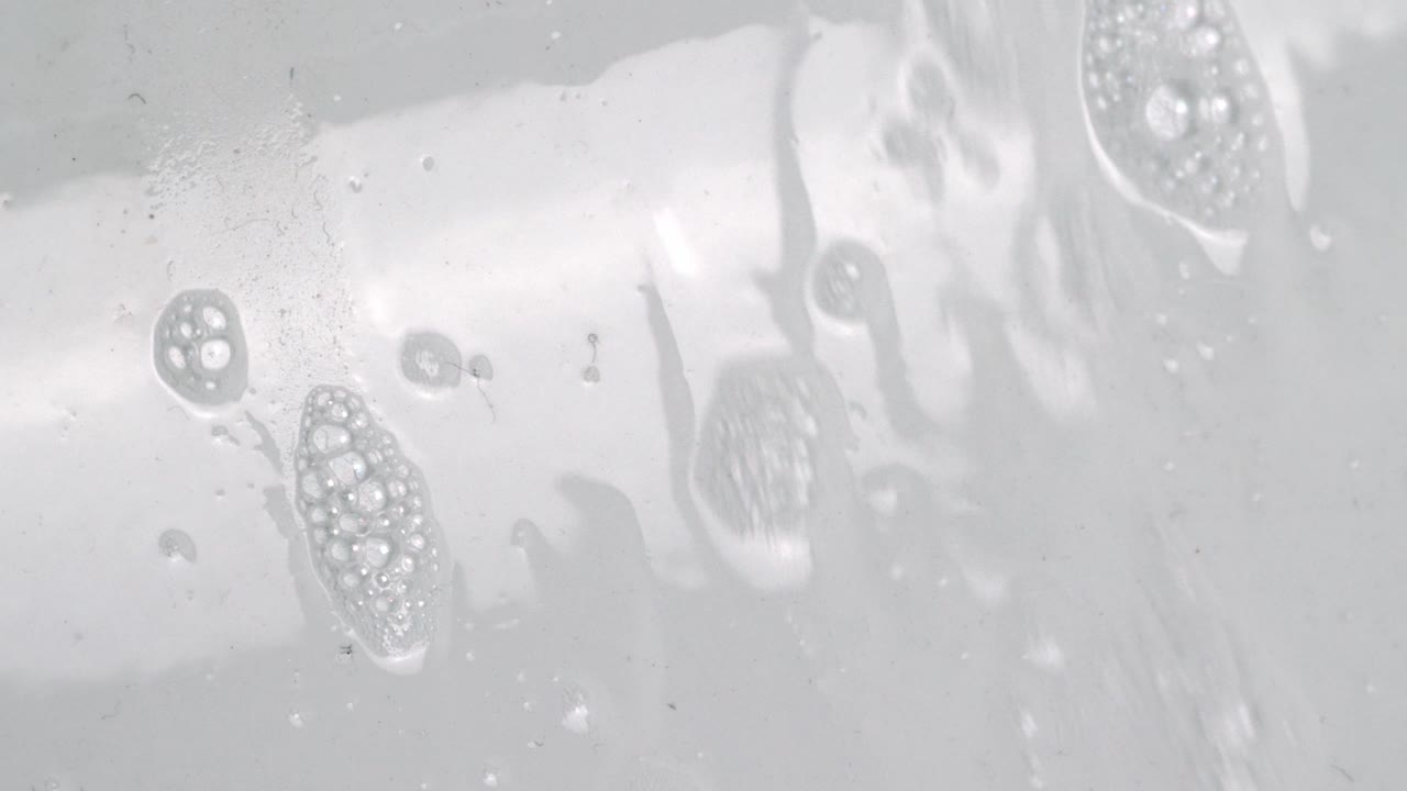 흰색 광택 벽에 흐르는 비눗물