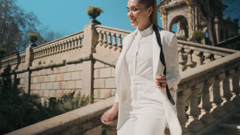 Stylish-young-woman-running-down-the-stairs-outdoors.