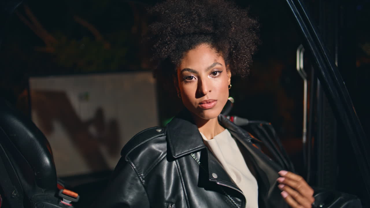 Trendy model posing night area looking camera confidently closeup portrait