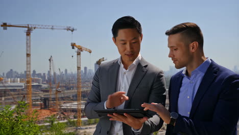 two businessmen reviewing plans at a construction site
