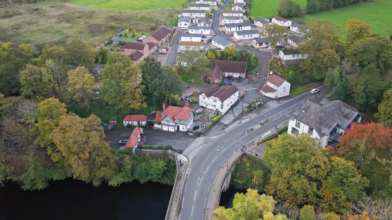 Overhead shot showing Knaresborough's historic riverside houses, bridge crossing River Nidd, tree-lined streets, surrounding green spaces and village layout in North Yorkshire, England