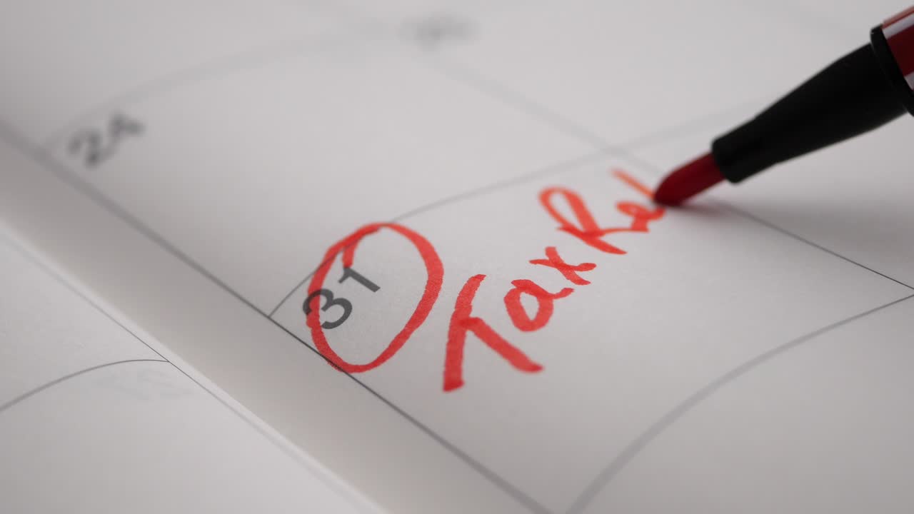 Segnare la scadenza della dichiarazione dei redditi sul calendario con una penna rossa