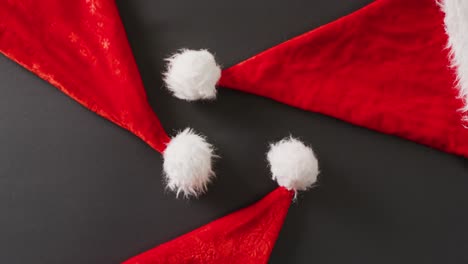 video of close up of santa hats on gray background