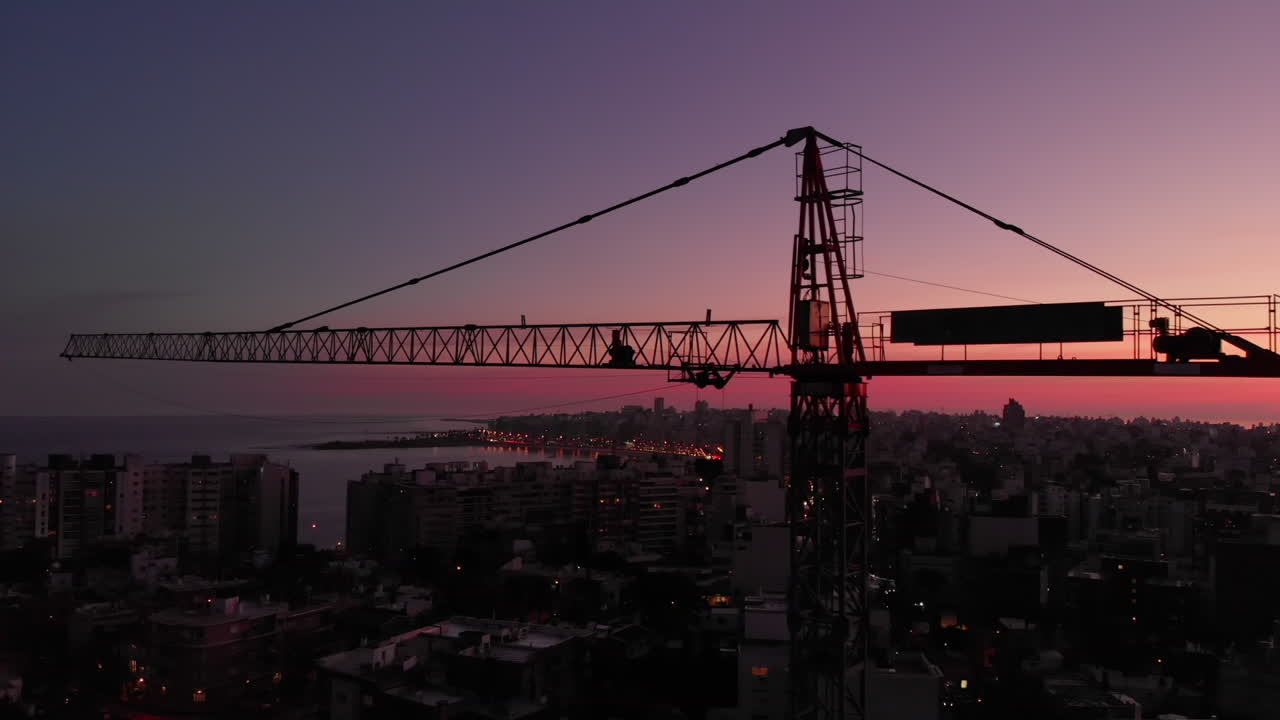 grúa de construcción en la ciudad al atardecer sobrevuelo