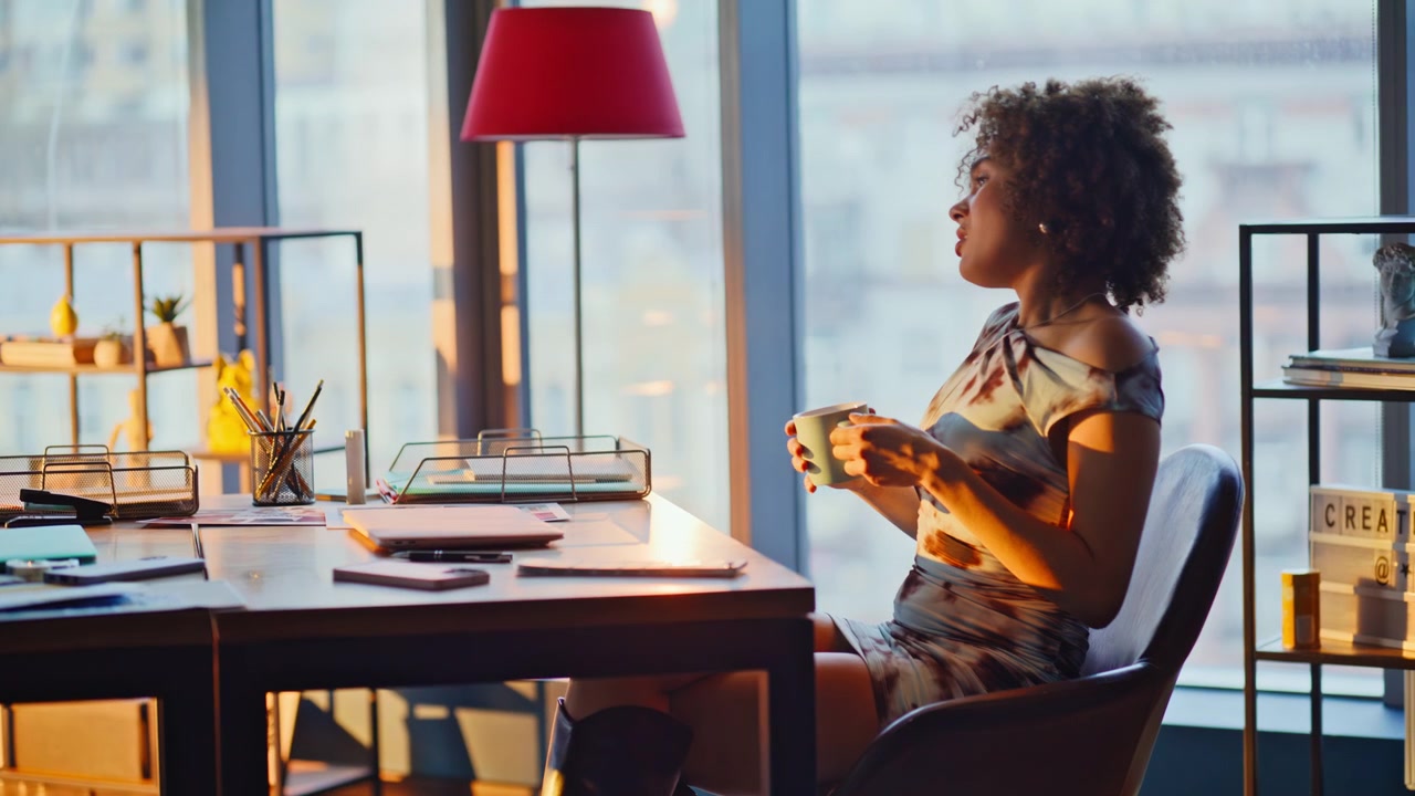 Coworkers discussing project ideas over coffee in creative sunset office space