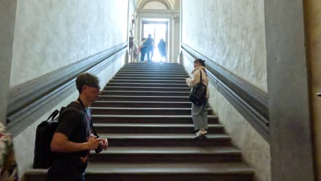 visitantes subiendo las escaleras en la galería uffizi, florencia