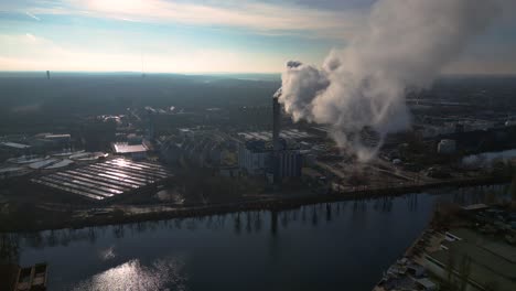 industrial chimneys emitting white smoke over city skyline under blue sky, concept of pollution. unbelievable aerial view flight panorama overview drone