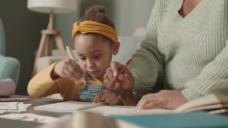 woman helping daughter doing homework