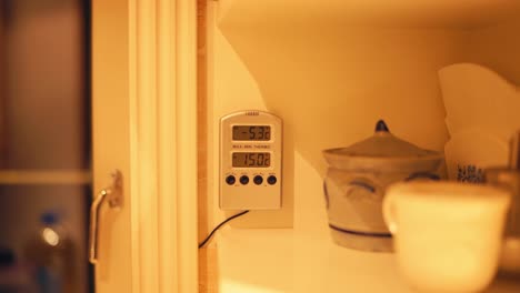 termómetro digital montado en la pared interior de una casa con iluminación cálida