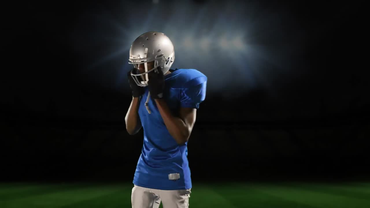 Professional American football player standing in front of a sports stadium