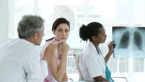 Equipo-Médico-Serio-Examinando-Una-Radiografía