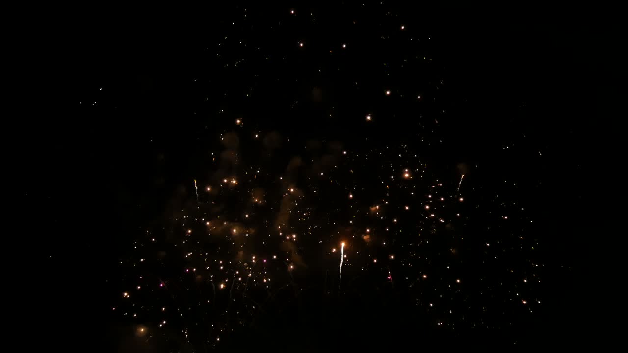 4k tiro largo 29s. hermoso de fondo de fuegos artificiales coloridos reales durante la celebración de la cuenta atrás de la víspera de año nuevo, festival de fuegos artificiales dorados brillantes en la exhibición del cielo por la noche. espectáculo de fuelos artificiales brillantes